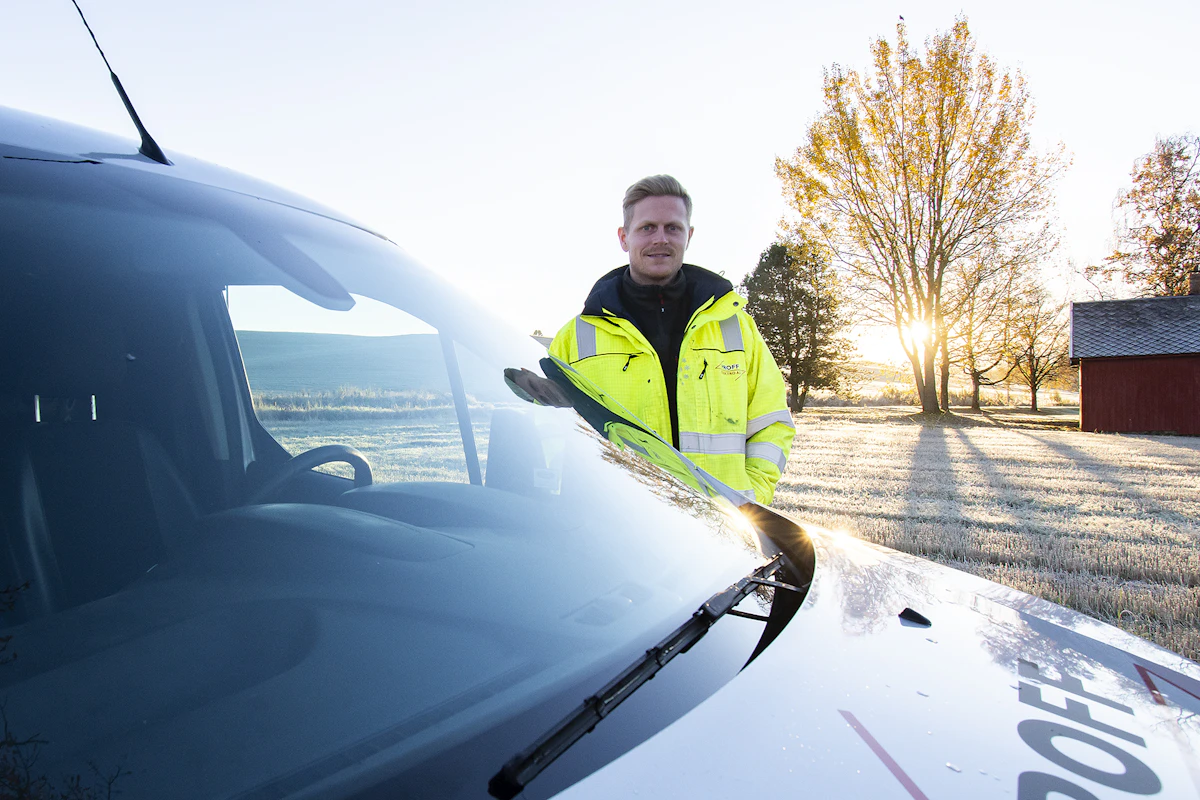 Montør fra Proff Elektro står ved bil i soloppgang