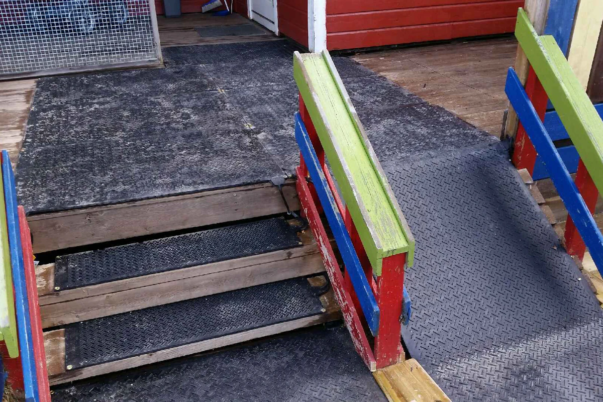 En kombinasjon mellom store og små varmematter fra IsFritt lagt på trapp og helling, for rullestolbrukere, utenfor en barnehage. Foto
