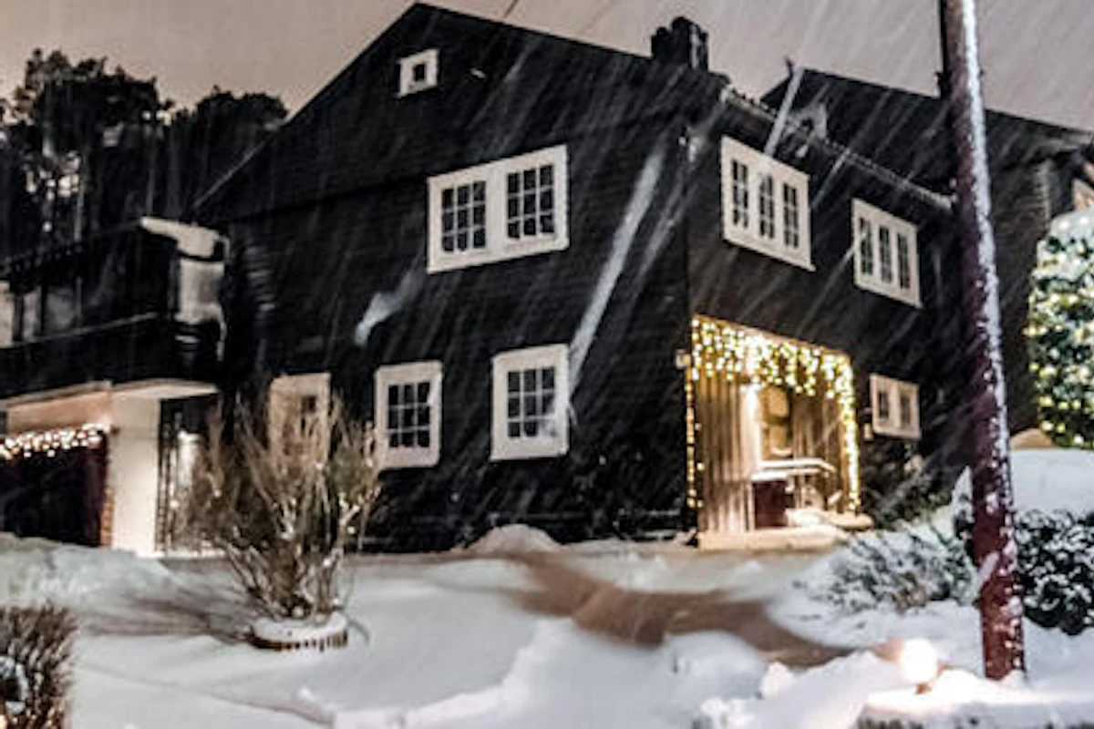 Et mørk hus, men med flott lyssetting i vinterlandskap. Foto