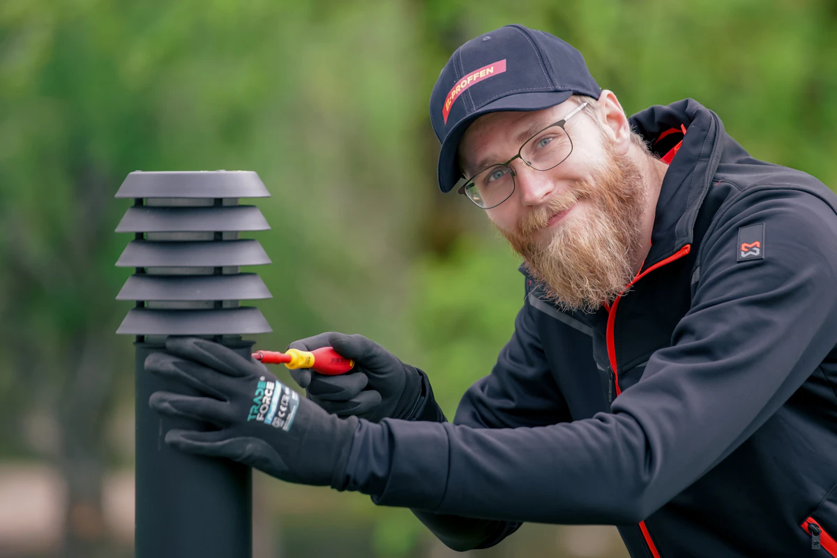 Elektriker fra EL-PROFFEN som fikser en utendørs lampe med skrujern. Foto