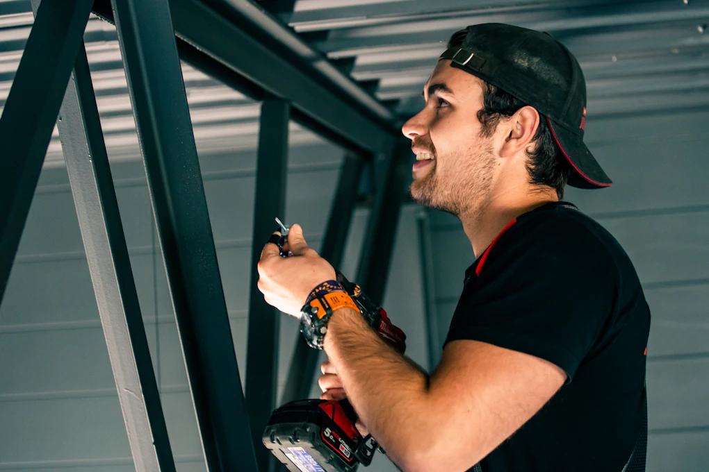 Elektriker skal skru fast ledninger i taket på næringsbygg. Foto.