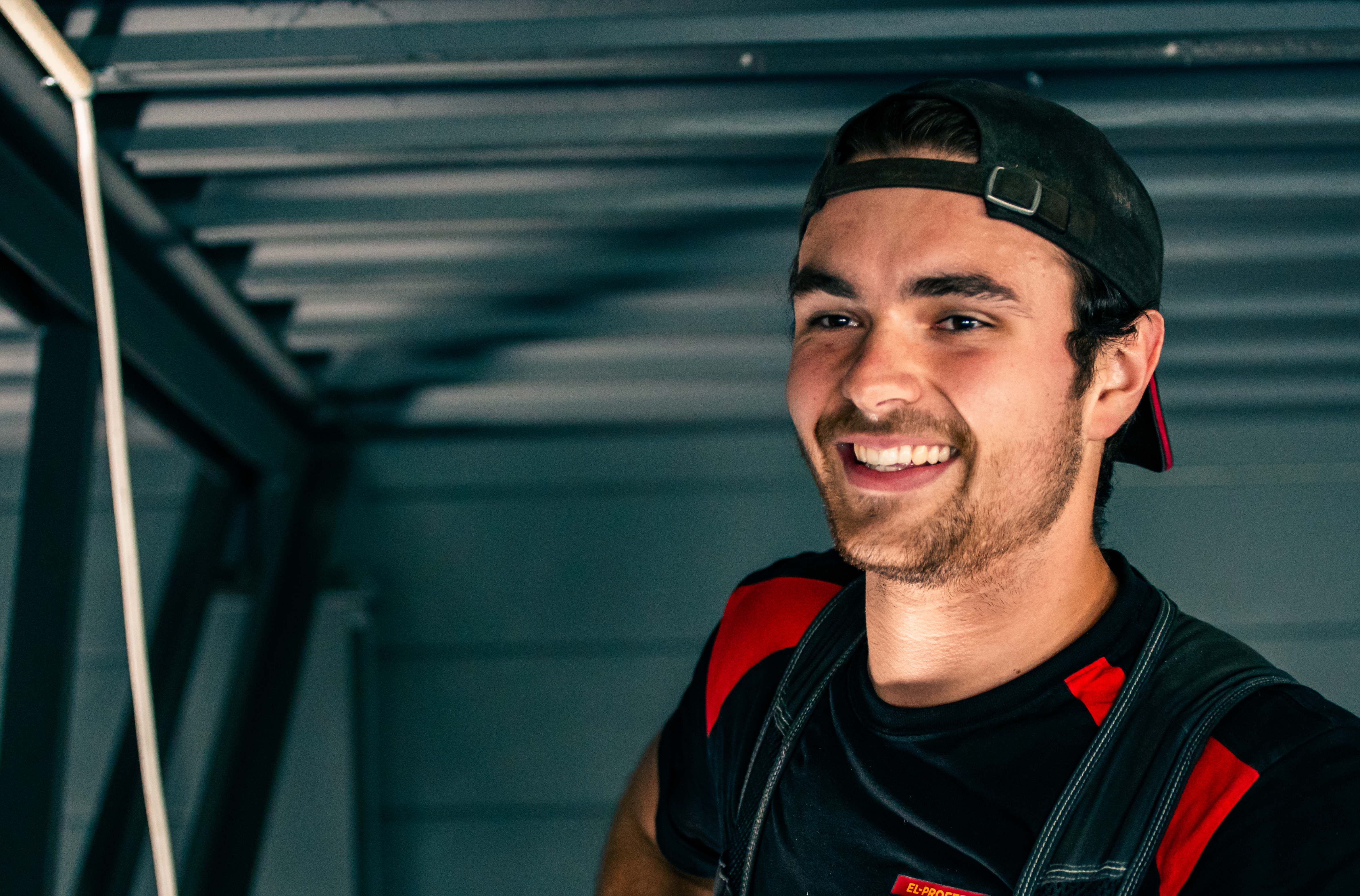 Elektriker smiler og er fornøyd med innsatsen. Foto.