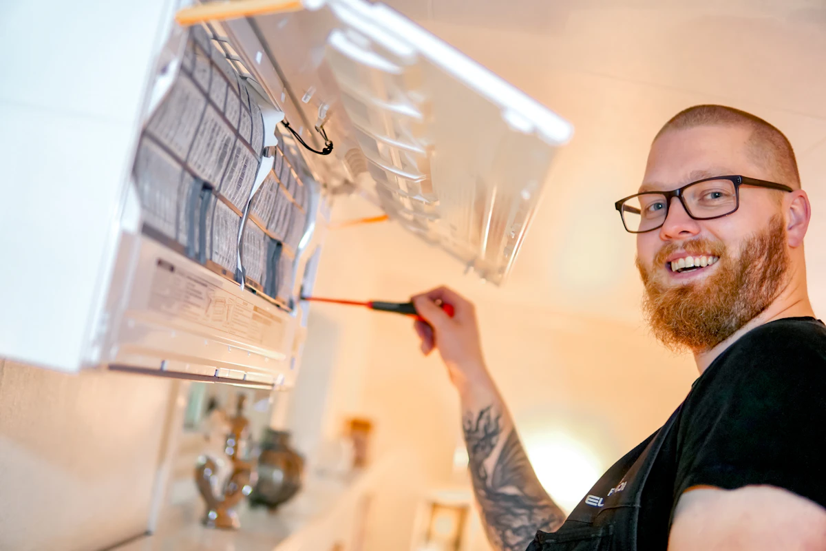 Varmepumpe installert av elektriker i EL-PROFFEN, med et smil. Foto.