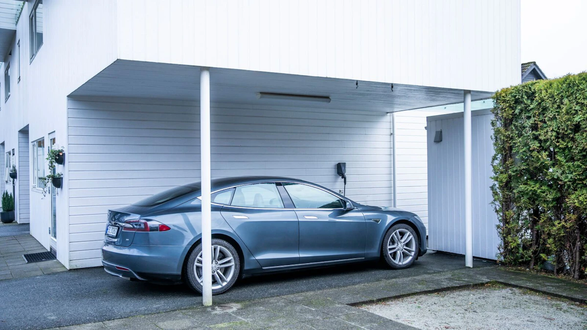 Tesla som står til lading i en carport. Foto