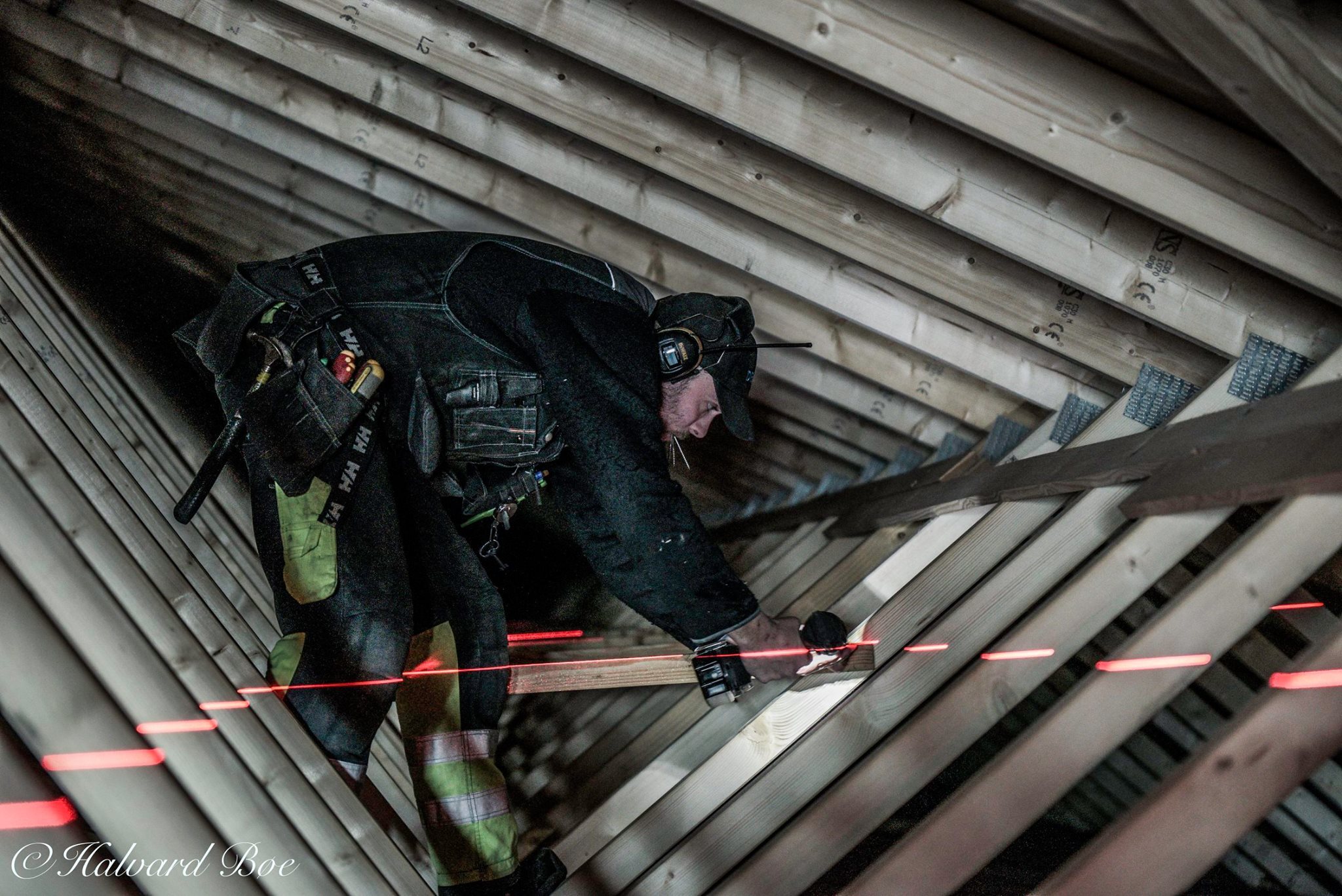 Elektriker monterer føringsveier oppe på loft med laser. Foto