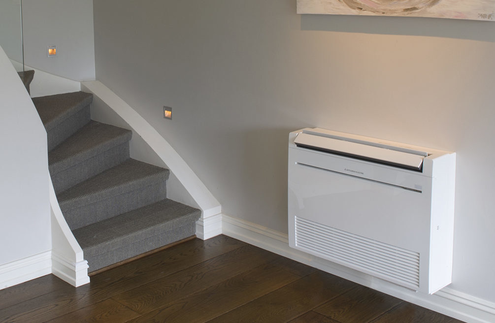 Mitsubishi Electric Furo hvit varmepumpe gulvmodell plassert ved trapp. Foto