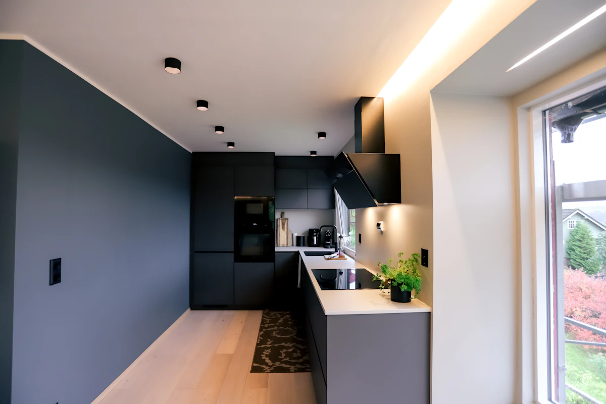 Kjøkken med store sorte downlight kombinert med lyslist. Foto