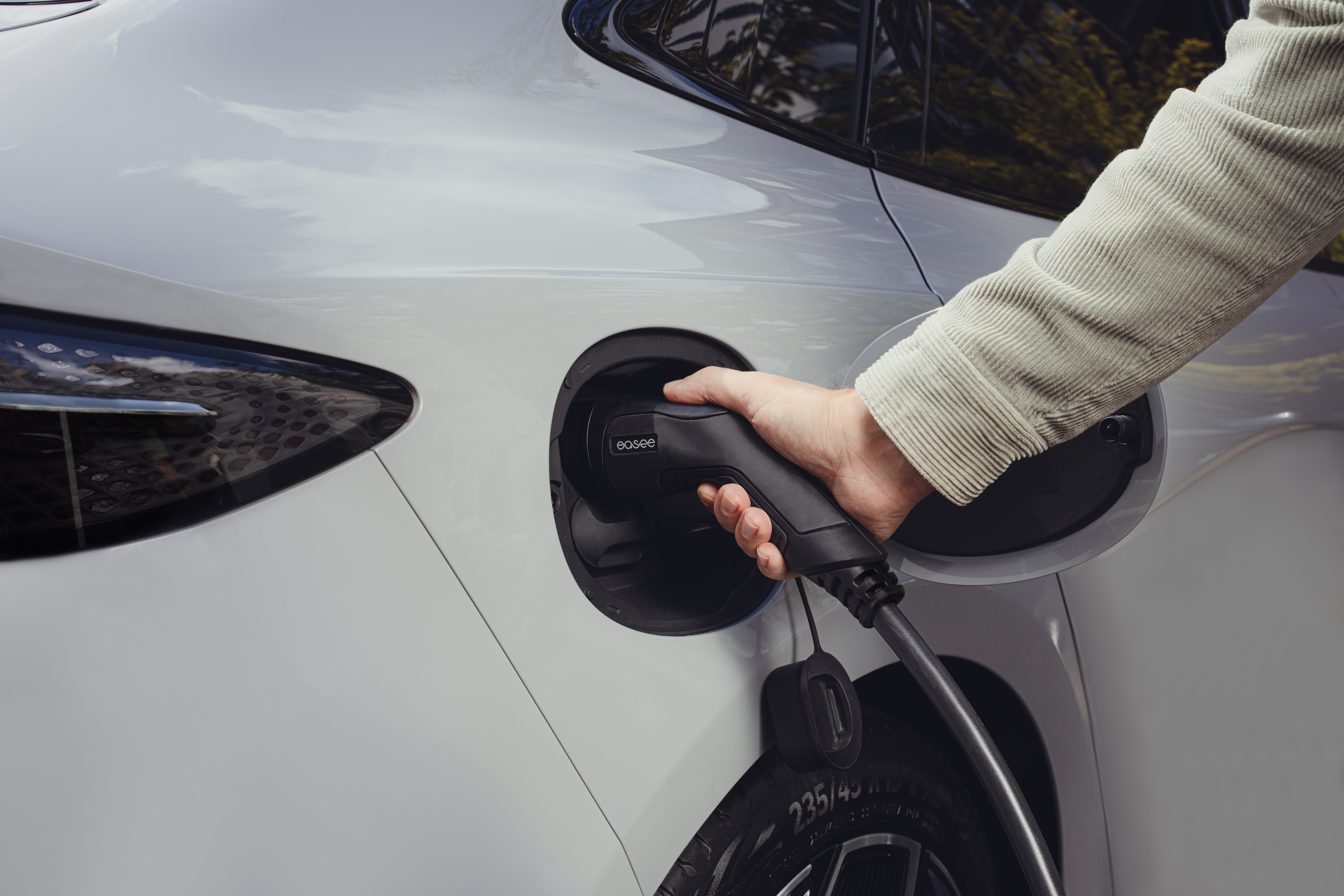 Ladekabel fra EASEE plugget inn i hvit bil for lading. Bilde