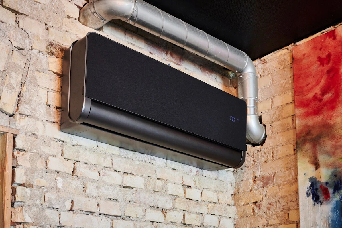 Bildet viser en ELL Front Varmepumpe på murvegg. Foto.