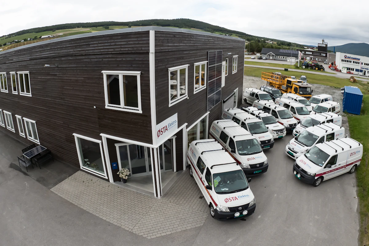Hovedkontoret på Tynset med oppstilling av firmabiler fra Østa Elektro. Foto