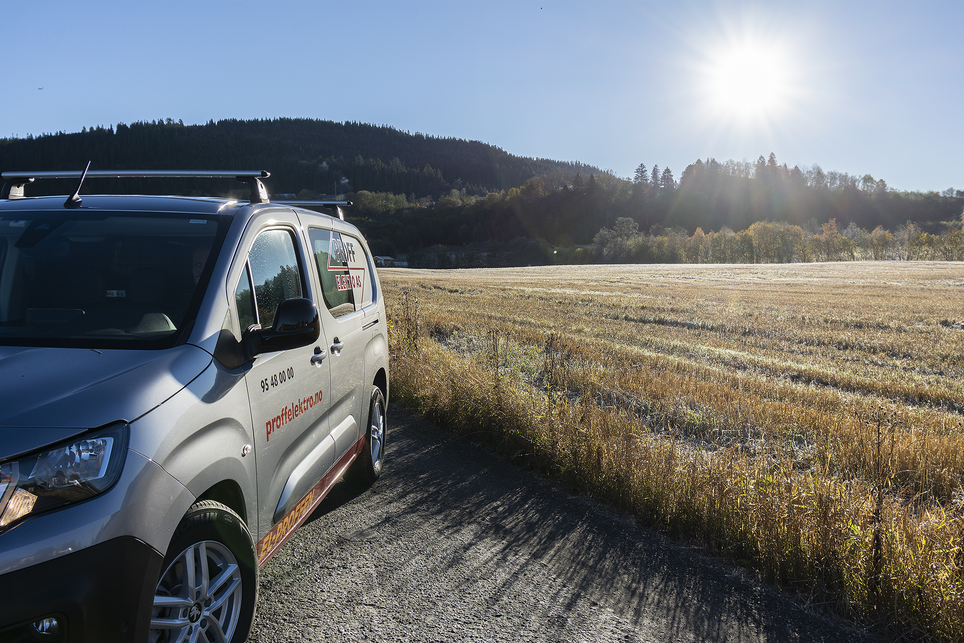Bilde av servicebil fra Proff Elektro på landevei med sol i bakgrunnen.