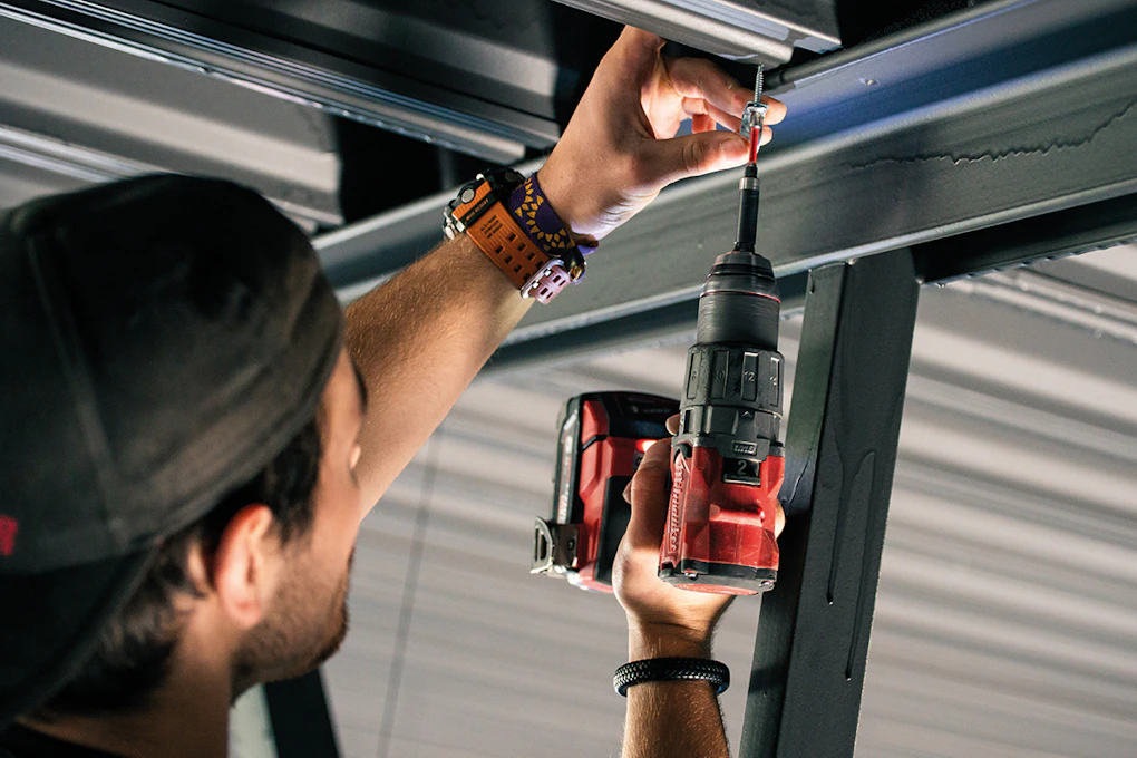 Elektriker skrur fast rør til ledninger. Foto